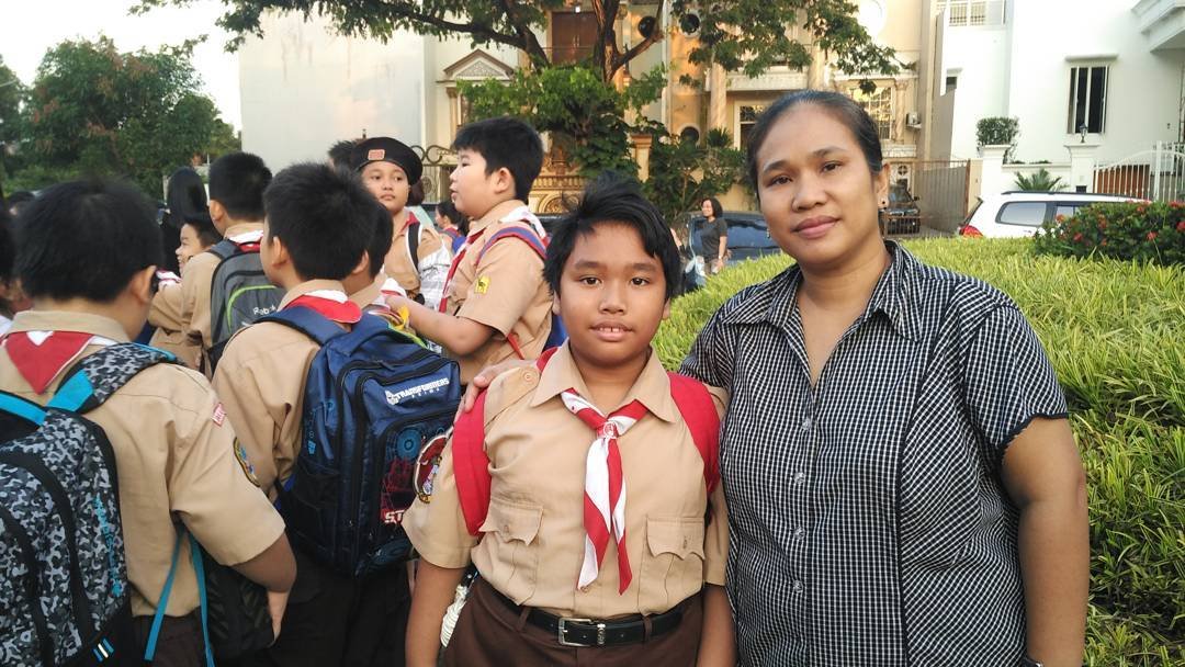 Ibu mengantar anaknya untuk mengikuti kegiatan Pramuka
