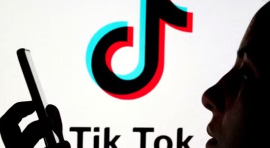 smartphone dengan latar belakang logo TikTok